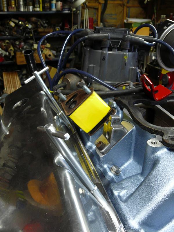 P1180149.JPG - The EGR valve hit the valve cover so Win machined a two inch high block of steel (the yellow lump in the picture) to raise the valve above the cover.  The engine now uses an Edelbrock Performer intake.  Win's now milling a block of oak wood into a heat insulator for the Rochester Quadrajet carb that fits up with all the pollution control jazz.